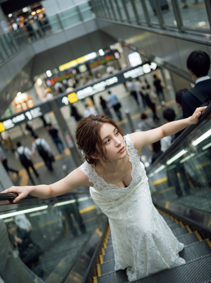 La mariée en robe de rêve sur l'escalator à la gare d'Osaka